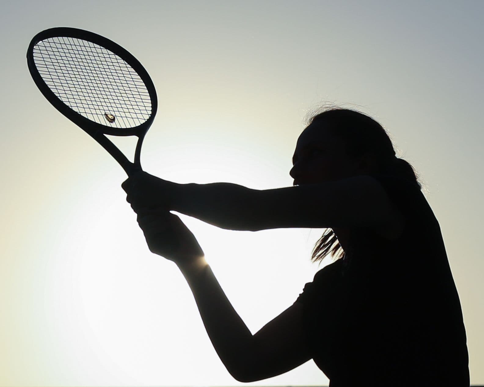 Coach Karina hitting backhand under sunset
